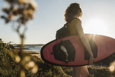 Teenager-Mädchen am Strand mit Surfbrett - UUF08515