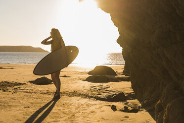 Teenager-Mädchen am Strand mit Surfbrett - UUF08523