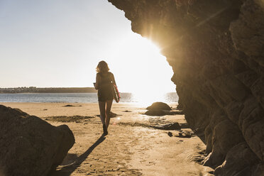 Teenager-Mädchen am Strand mit Surfbrett - UUF08524