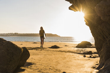 Teenager-Mädchen am Strand mit Surfbrett - UUF08525