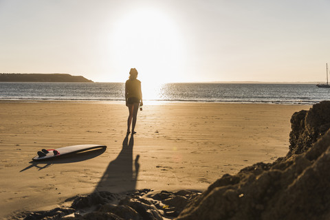 Teenager-Mädchen steht am Strand und schaut auf das Meer, lizenzfreies Stockfoto