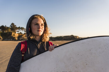 Teenager-Mädchen am Strand mit Surfbrett - UUF08538