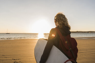 Teenager-Mädchen am Strand mit Surfbrett - UUF08539