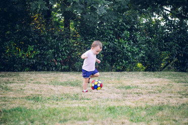 Baby boy playing soccer on a meadow - JPSF00007