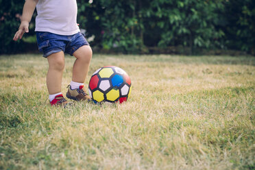 Baby boy playing soccer on a meadow, partial view - JPSF00012