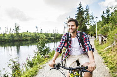 Young man riding bicycle in nature - HAPF00846
