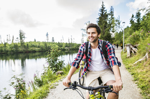 Junger Mann fährt Fahrrad in der Natur - HAPF00846