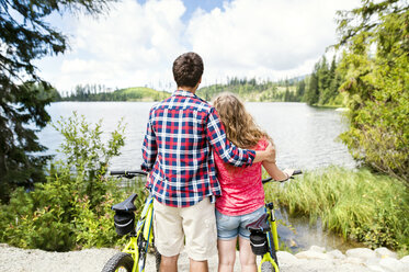 Young couple looking at view on a bicycle trip - HAPF00858