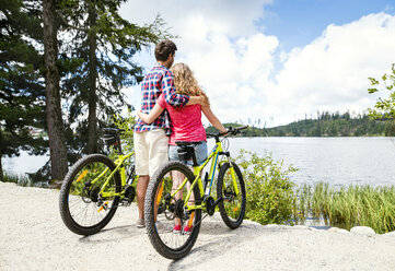 Young couple looking at view on a bicycle trip - HAPF00859