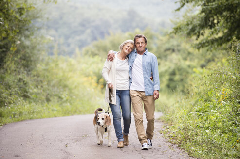 Älteres Paar auf einem Spaziergang mit Hund in der Natur - HAPF00869