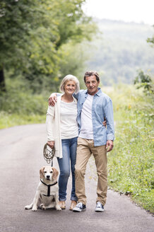 Porträt eines glücklichen älteren Paares mit Hund in der Natur - HAPF00871