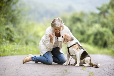 Ältere Frau mit ihrem Hund in der Natur - HAPF00886