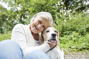 Happy senior woman cuddling her dog - HAPF00887