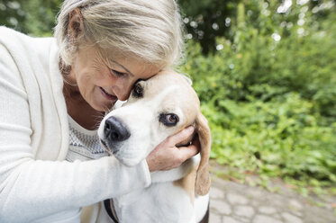 Happy senior woman cuddling her dog - HAPF00889