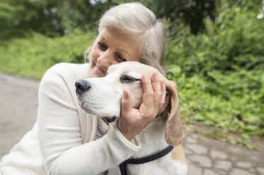 Happy senior woman cuddling her dog - HAPF00890