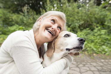 Glückliche Seniorin, die ihren Hund knuddelt - HAPF00891