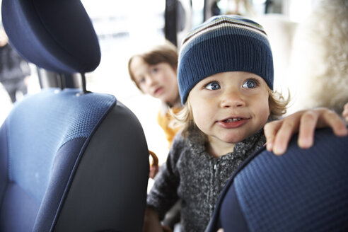 Kleiner Junge sitzt mit Brüdern im Auto - FSF00449