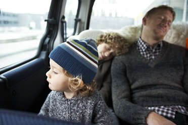 Sleeping father sitting in car on back seat with his sons - FSF00454