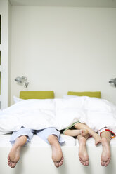 Familie im Bett eines Hotelzimmers liegend - FSF00495