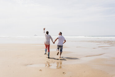 Mature couple running on the beach - UUF08578