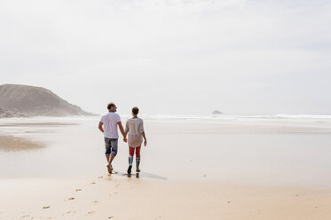 Mature couple walking on the beach - UUF08580