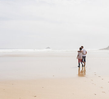 Mature couple walking on the beach - UUF08582