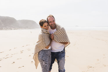 Mature couple walking on the beach - UUF08590