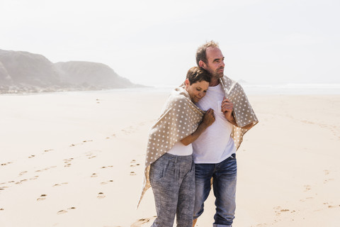 Älteres Paar beim Spaziergang am Strand, lizenzfreies Stockfoto