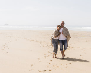 Mature couple walking on the beach - UUF08593