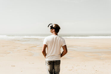 Reifer Mann steht am Strand und trägt eine VR-Brille - UUF08598