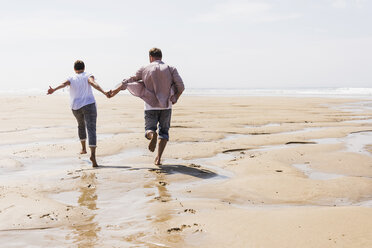 Älteres Paar läuft am Strand - UUF08600