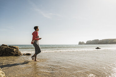 Mature woman wading in the sea - UUF08604