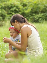 Mother and baby boy together on a meadow - LAF01726