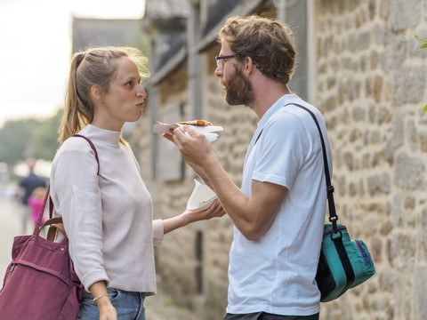 Frankreich, Bretagne, junges Paar isst Crepes, lizenzfreies Stockfoto