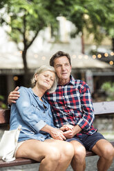 Senior couple relaxing on bench watching something - HAPF00896