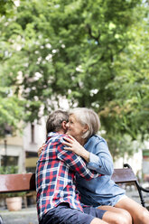Happy senior couple hugging on a bench - HAPF00899