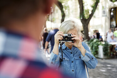 Ältere Frau, die ihren Partner mit der Kamera fotografiert - HAPF00938