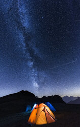 Italy, Dolomites, Milky Way over Monte Pelmo with tents of camp in the foreground - LOMF00400