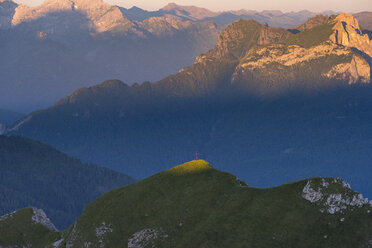 Italien, Dolomiten, Sonnenlicht auf einem Gipfelkreuz - LOMF00404
