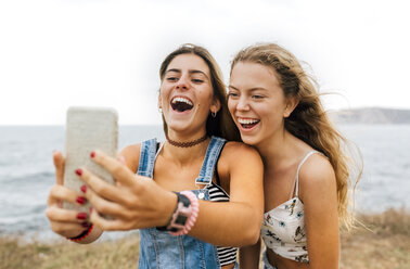 Two best friends taking selfie with smartphone at the coast - MGOF02448