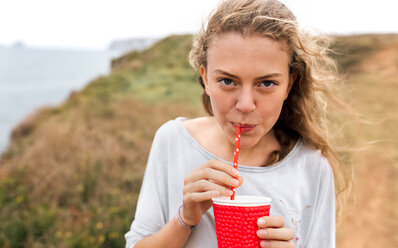 Porträt eines Teenagers mit Getränk an der Küste - MGOF02461