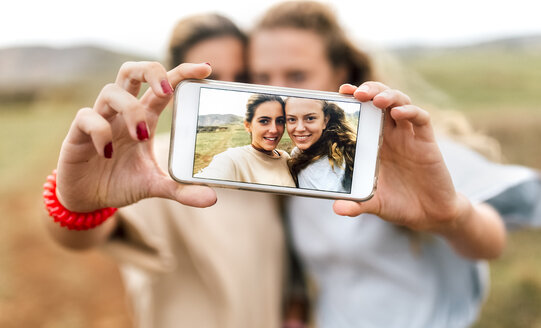 Selfie von zwei lächelnden Teenagern auf dem Display eines Smartphones - MGOF02463