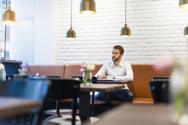 Geschäftsmann sitzt mit einer Tasse Kaffee in einem Café - DIGF01240