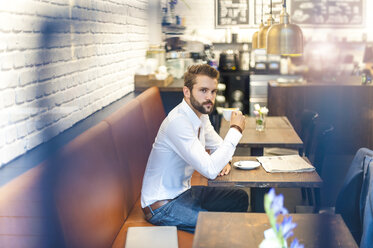 Businessman sitting in a cafe with cup of coffee - DIGF01247