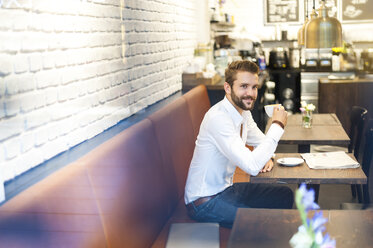 Geschäftsmann sitzt mit einer Tasse Kaffee in einem Café - DIGF01248