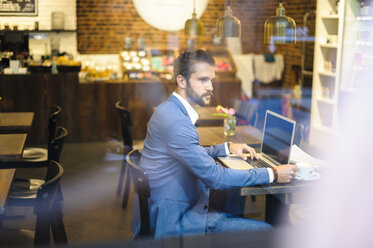 Businessman with laptop in a cafe - DIGF01258