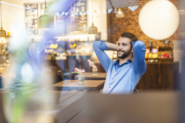 Lächelnder junger Mann in einem Cafe - DIGF01280