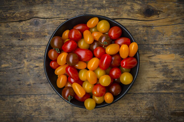 Bowl of yellow and red mini tomatoes on wood - LVF05330