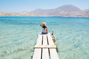 Griechenland, Kykladen-Inseln, Amorgos, Frau sitzt auf dem Rand eines Holzstegs, Insel Nikouria - GEMF01023