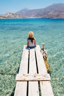 Griechenland, Kykladen-Inseln, Amorgos, Frau sitzt auf dem Rand eines Holzstegs, Insel Nikouria - GEMF01024